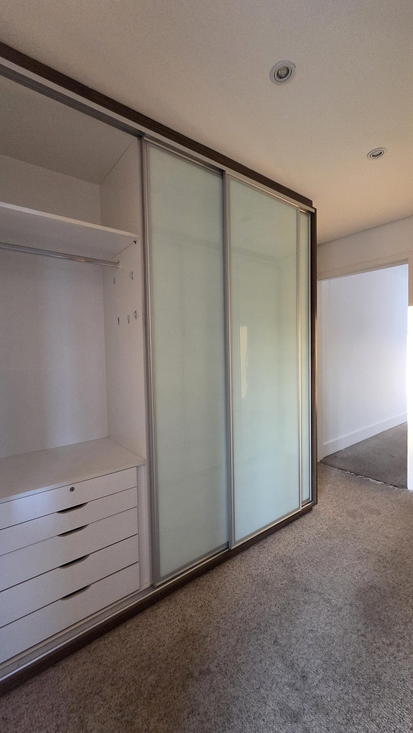 Closet planejado com portas de vidro na suíte master